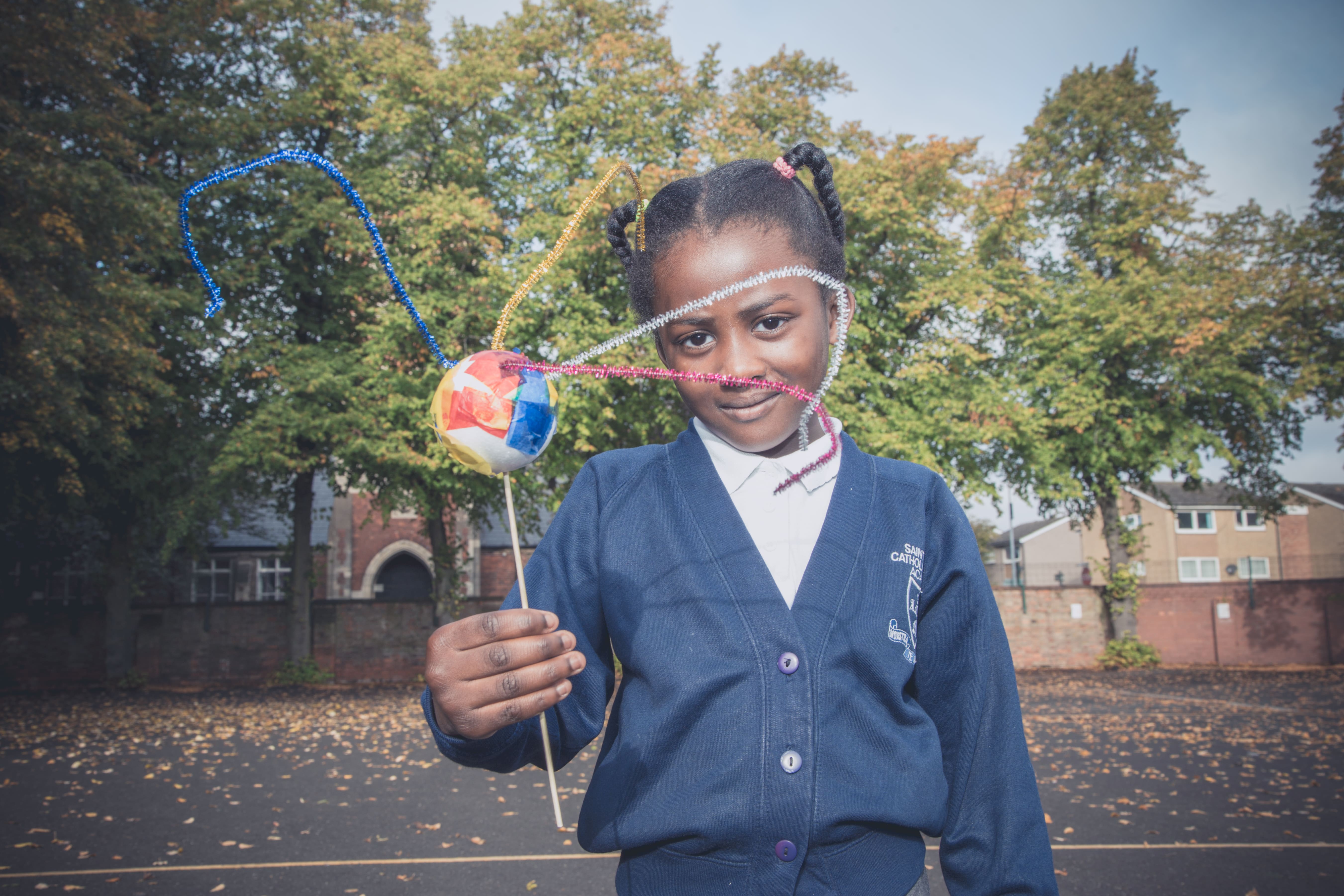 Photo of girl holding up craft work